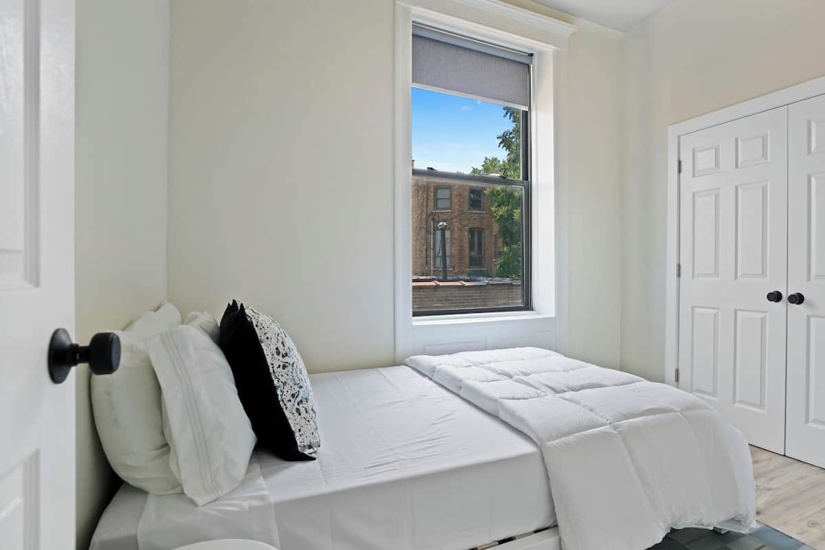 Une chambre à coucher avec un lit, une fenêtre et une porte.