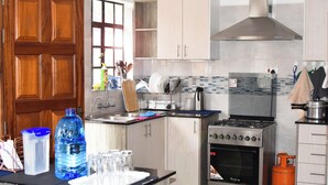 Eine Küche mit Holzschränken, einem Gasherd, einem Backofen und einem Wasserspender.