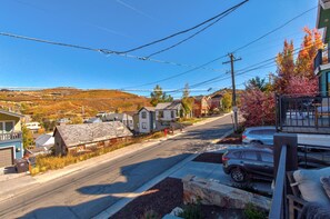 A residential street with houses, a clear sky, and power lines. - Walk to Ski Slopes + Trails! Luxury 4-Bedroom Private Home with Private Hot tub, A/C, Heated Parking, and Two Master Suite! | PEA-1009 by KBM Resorts (Park City)