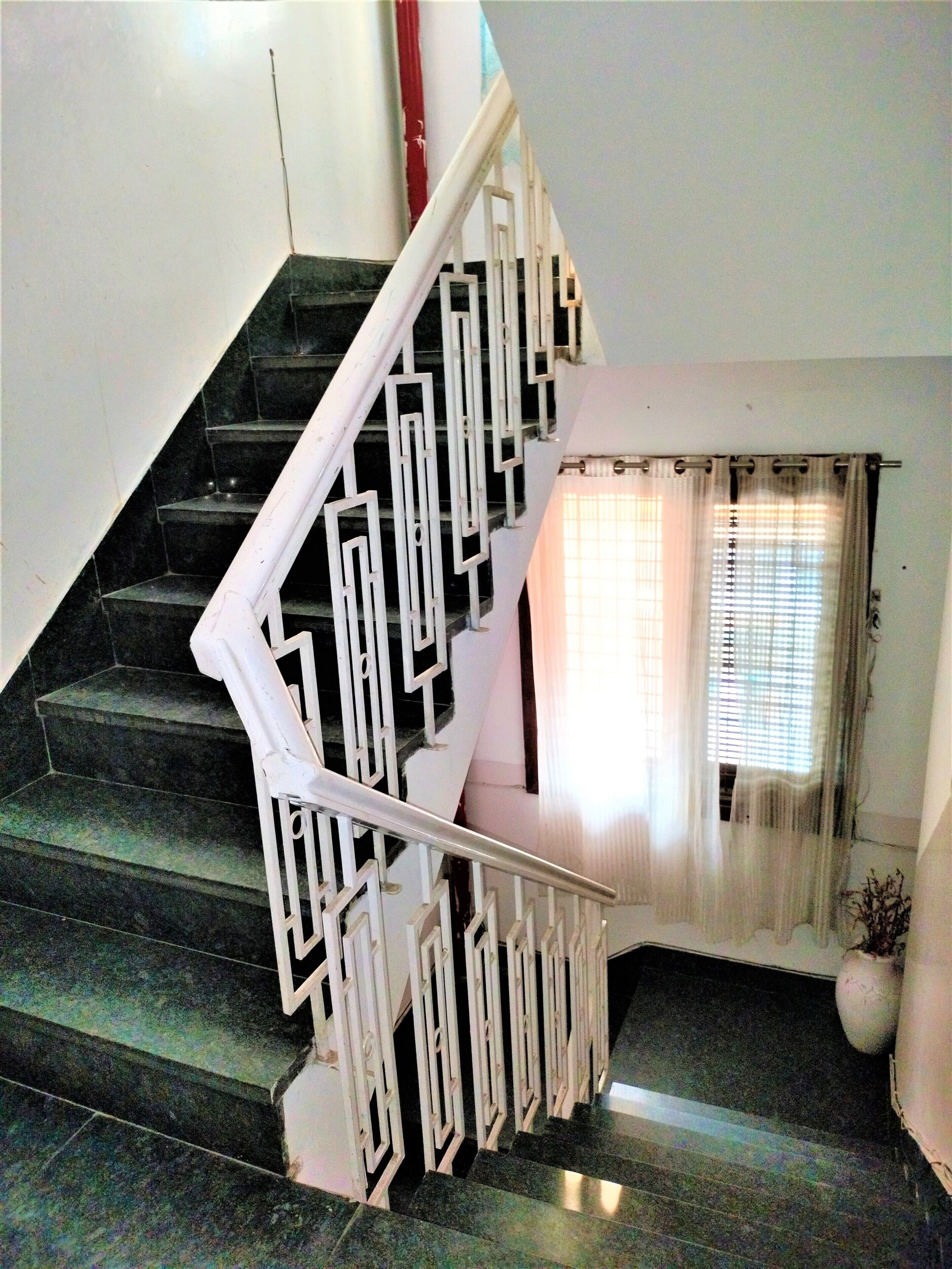 A staircase with a white railing and black steps.