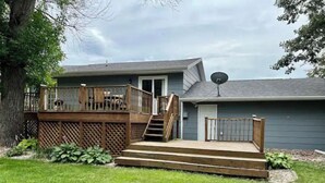 A residential property with a deck, stairs, and a satellite dish.