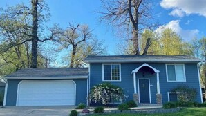 A two-story house with a garage, a front porch, and a well-maintained lawn.