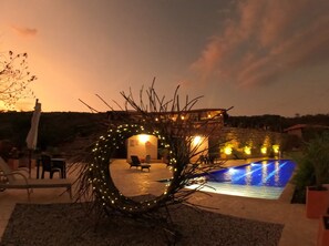 A pool area with a stone building, outdoor seating, and a decorative archway. - Hotel Boutique Feria Internacional  (Bogotá)