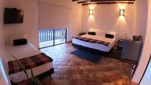 A bedroom with two beds, a ceiling fan, a TV, and a balcony with a view.