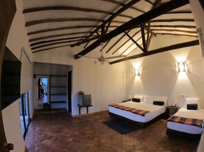 A room with two beds, a wooden ceiling, and a small table. - Hotel Boutique Feria Internacional  (Bogotá)