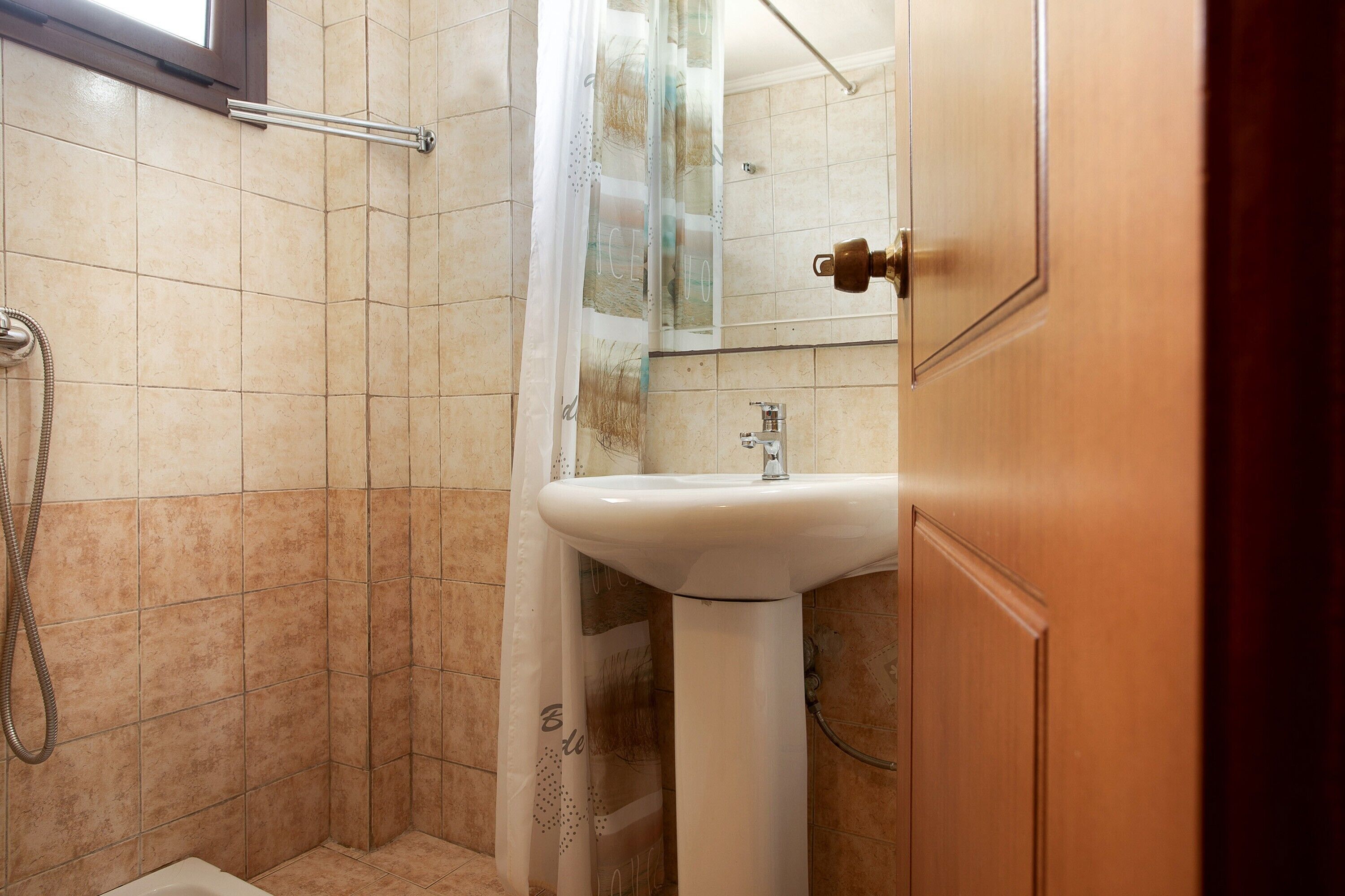Une salle de bain avec une douche, un lavabo et un miroir.