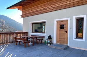 Ein Holzhaus mit Balkon, einer Holztür und einem Fenster.