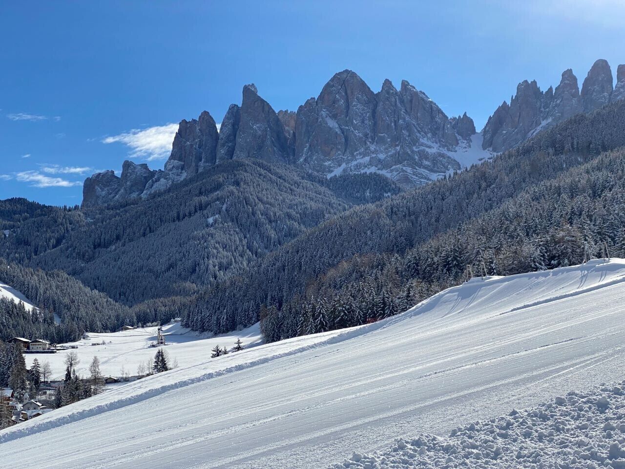 A snow-covered mountain landscape with rocky peaks and dense forests.