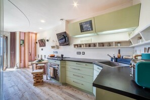 Una cocina moderna con una isla curva, armarios empotrados y un tostador.