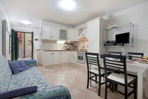 A compact living space with a kitchenette, a dining area with a table and chairs, and a sofa with patterned upholstery. - Holiday Home 'Deiva' with Landmark View and Wi-Fi (Deiva Marina (SP))