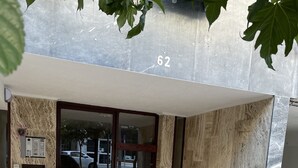 A building entrance with a marble facade, a glass door, and a number '62' above the door. - Charming 2-bed Apartment in Kallithea (Kallithea)