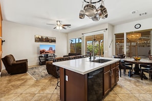 A spacious kitchen with a large island, modern appliances, and a dining area with a chandelier.