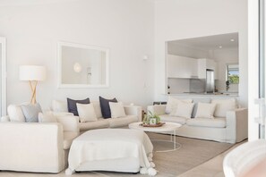 A modern living room with a sofa set, a coffee table, and a mirror.
