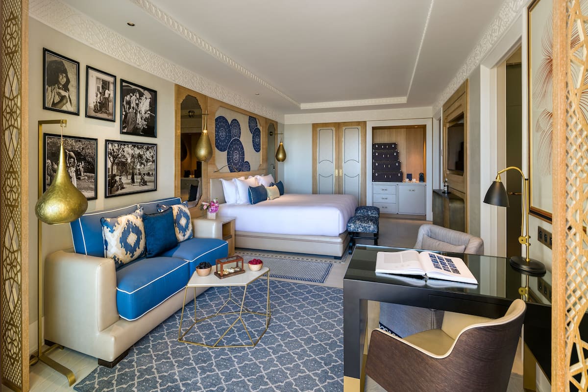Une chambre d’hôtel moderne équipée d’un lit, d’un canapé, d’un bureau et d’un coin repas.