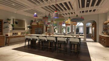 Una cocina amplia con una isla central, varias lámparas colgantes y un diseño de techo moderno.