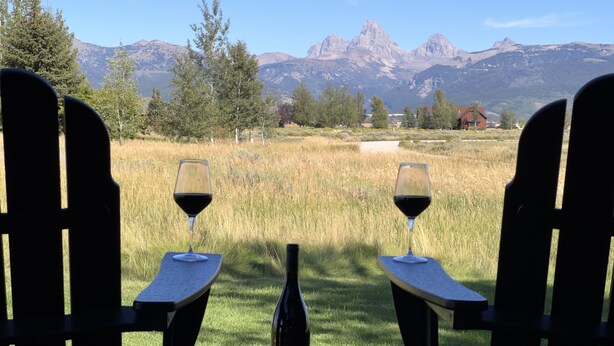 Two Adirondack chairs facing a mountain view with a bottle of wine on the ground between them. - Peaceful 3BR - 20mins from Resort + Stunning Grand Teton Views! (Tetonia)
