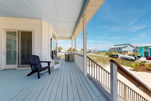 Relax in a tranquil outdoor space with a deck, Adirondack chairs, and a small table.
