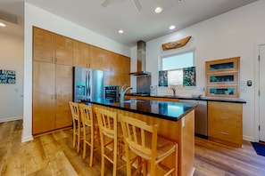 Enjoy cooking in this well-equipped kitchen with a central island, cabinets, and stainless steel appliances.