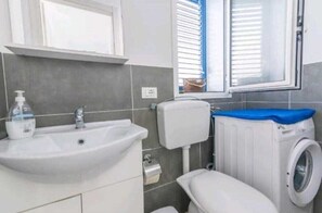 Regadera, secadora de cabello, bidet, toallas