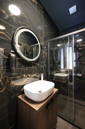 Habitación Deluxe | Baño | Ducha, cabezal de ducha tipo lluvia, secador de pelo y toallas