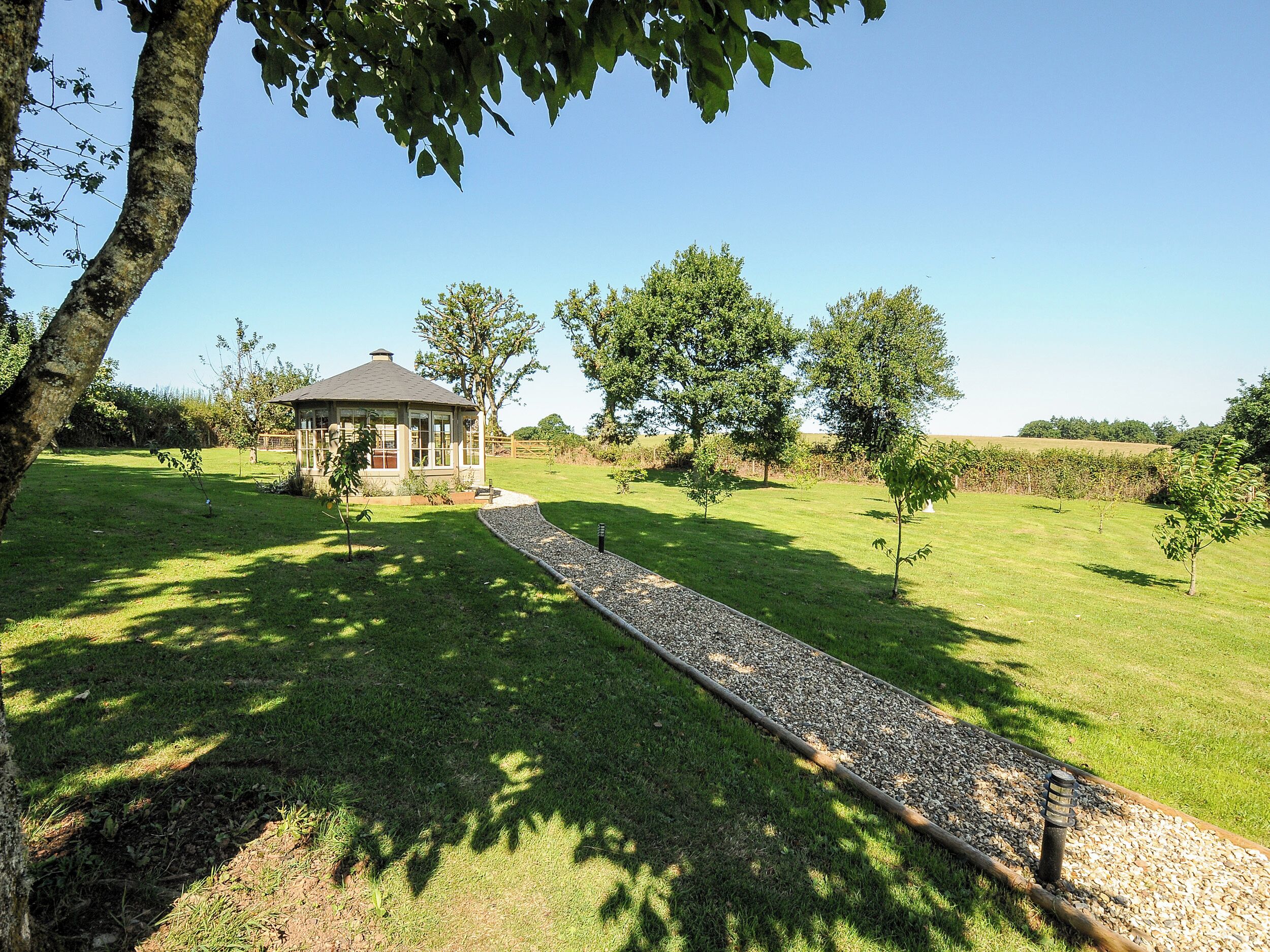 A house with a garden path leading to a gazebo.