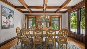 A dining room with a wooden ceiling, large windows, and a chandelier. - Historic Family Home with 8 BDRMS, 8 BATHS & 3 Kitchens! (Spokane)