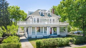 A two-story house with a porch, a chimney, and a flag. - Historic Family Home with 8 BDRMS, 8 BATHS & 3 Kitchens! (Spokane)