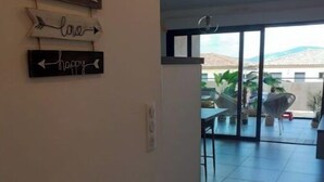 Ein Flur mit Blick auf einen Balkon, der mit Gartenmöbeln und Pflanzen ausgestattet ist.