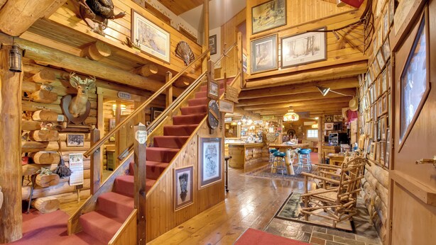 Un interior de madera con una escalera, paredes de madera y diversos objetos colgados.