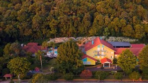 A colorful hotel with multiple buildings, surrounded by dense forest. - HOTEL POUSADA DA NEVE (Nova Petropolis)