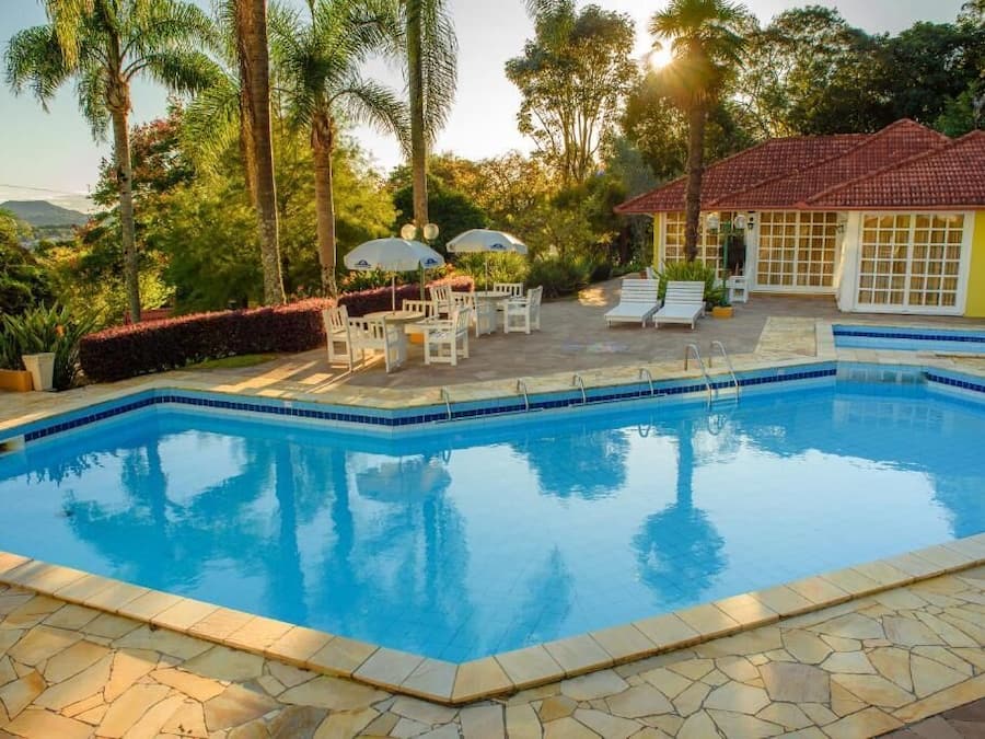 Una piscina al aire libre, sombrillas, sillones reclinables de piscina