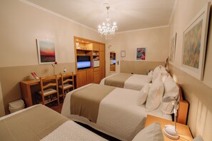 A hotel room with two beds, a desk, a TV, and a chandelier. - HOTEL POUSADA DA NEVE (Nova Petropolis)