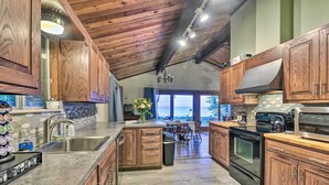 A spacious kitchen with wooden cabinets, a large island, and a view to the outside. - Lakefront Forestville Paradise w/ Private Beach! (Forestville)
