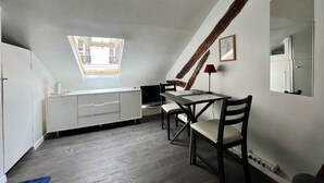 A small, modern kitchen with a skylight, a dining table, and a large mirror. - Charming, neat and bright studio, in a lively area, 15 minutes from the Louvre (Paris)