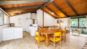 Enjoy a spacious room with a dining area, kitchenette, and seating area, offering a view of the surrounding greenery.