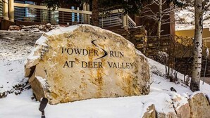 A large stone sign with the text "Powder Run at Deer Valley". - Powder Run by Park City Vacations (Park City)