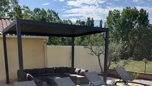 Un espacio de descanso al aire libre con sillones reclinables y un banco integrado.