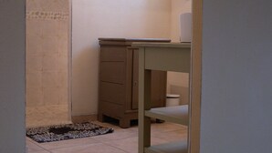 Un baño con inodoro, lavabo y mueble.
