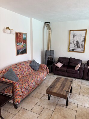 Ein Wohnzimmer mit einem gemusterten Sofa, einem Holztisch und einem Kamin.