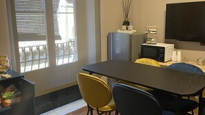 A modern kitchen with a dining table, chairs, and a TV. - Suite Ursino B&B (Catania)
