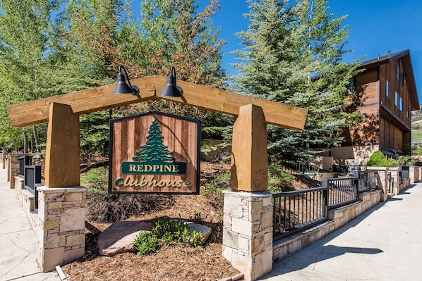 A wooden sign with a pine tree and the words "Redpine Clubhouse" under a wooden archway. - Red Pine Condos by Park City Vacations (Park City)