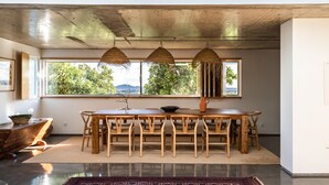 A dining area with a large table and chairs, a woven ceiling, and a view of greenery outside. - Countryside villa in the most magnificent views of Alentejo (Estremoz)