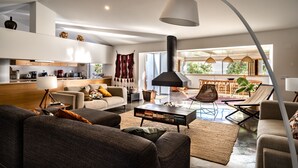 A modern living room with a sofa, coffee table, and a dining area with a table and chairs. - Countryside villa in the most magnificent views of Alentejo (Estremoz)