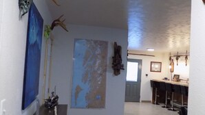 A hallway with wooden flooring, a map on the wall, and antlers on the walls. - Comfy Duplex Unit A great for families and small groups, sleeps up to 9 (Sitka)