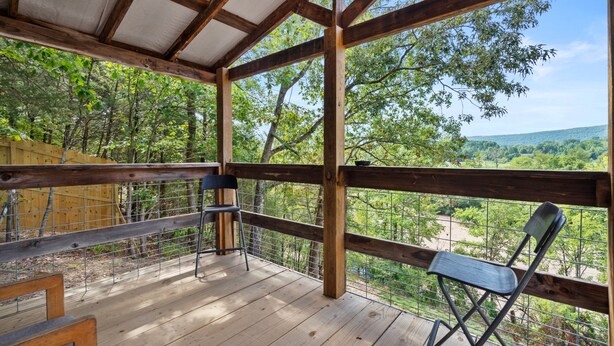 Une terrasse en bois offrant une vue sur un paysage boisé.