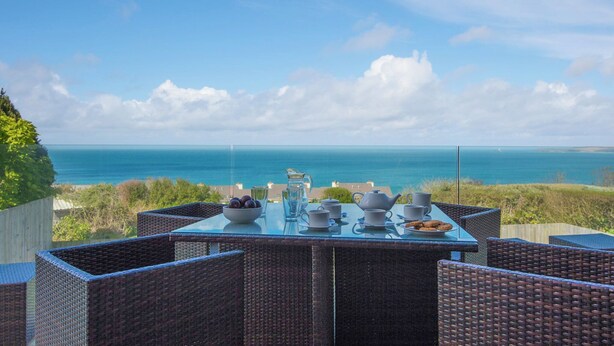 Een tafel gedekt voor thee, met uitzicht op de oceaan.
