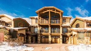 A multi-story building with a central atrium, stone facade, and multiple balconies. - Fairway Springs by Park City Vacations (Park City)