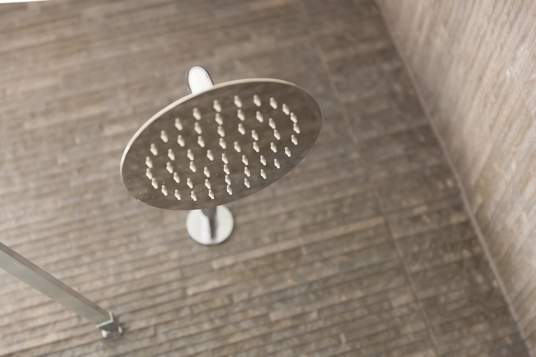 Un pommeau de douche au design circulaire et doté de plusieurs jets.