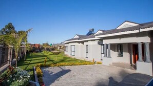 A residential area with modern houses, a well-maintained lawn, and a clear sky.