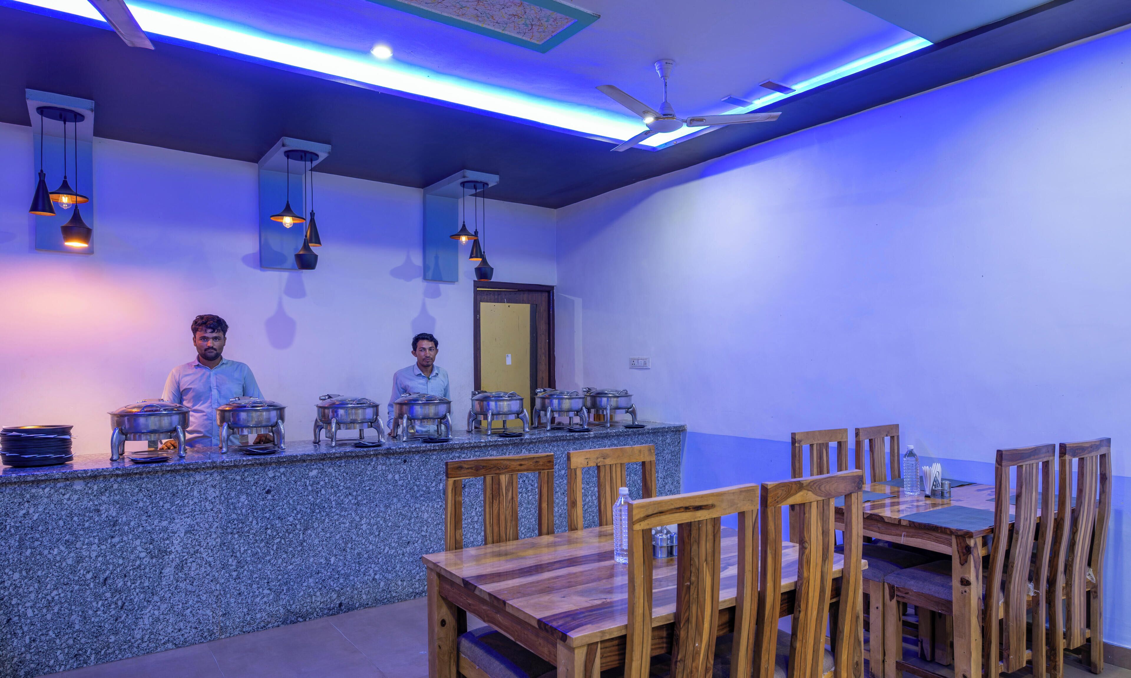 A restaurant with a granite counter, wooden chairs, and a ceiling fan.